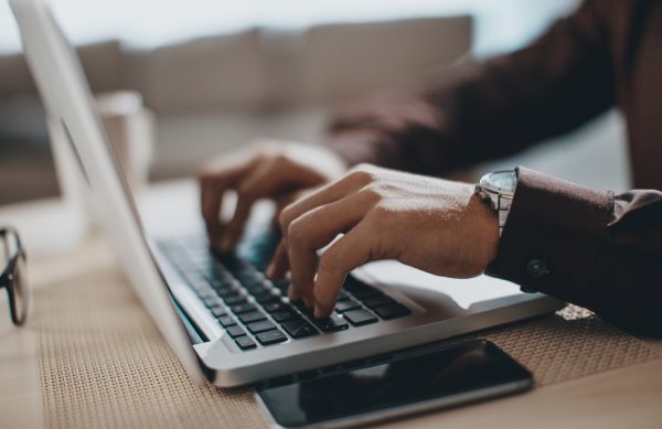 Hands typing on laptop computer